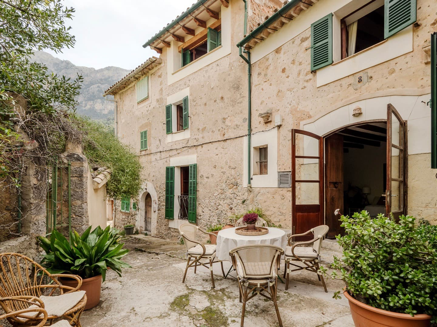Traditional stone villa in Deià with rustic courtyard, mountain views, and outdoor seating area.
