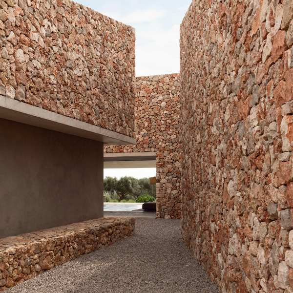 Contemporary Mediterranean architecture featuring natural stone walls and open passageway in a luxury Mallorca villa.