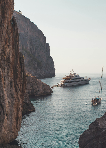 Scenic view of luxury yachts and sailboats along the rocky coastline of Palma de Mallorca in the Mediterranean Sea