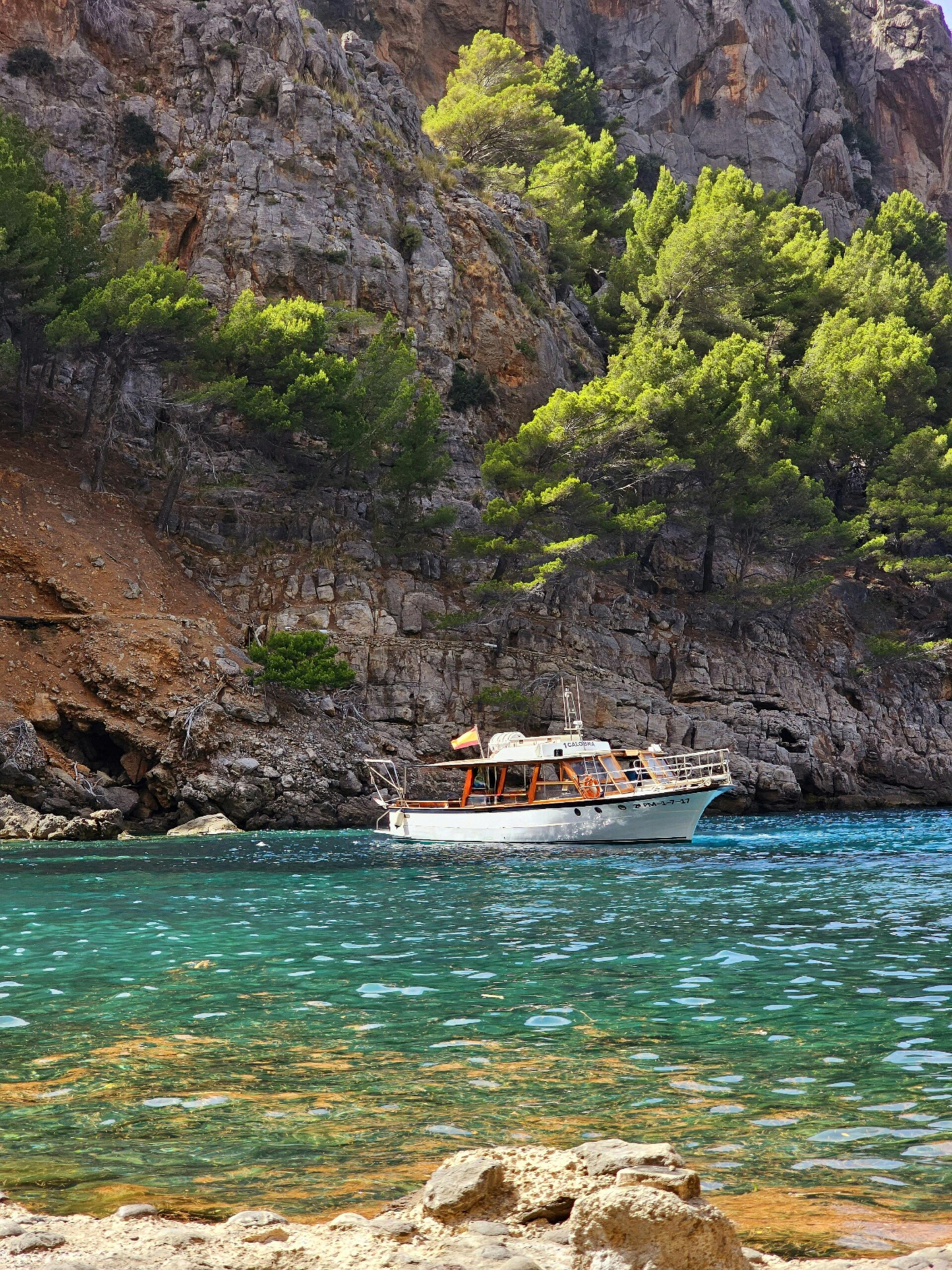 Servicio de barco privado por la costa de Mallorca, con parada en una cala aislada de aguas turquesas transparentes.