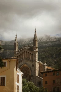 Church of Saint Bartholomew in Sóller Mallorca, a neo-Gothic landmark designed by Joan Rubió i Bellver, framed by the Tramuntana mountains