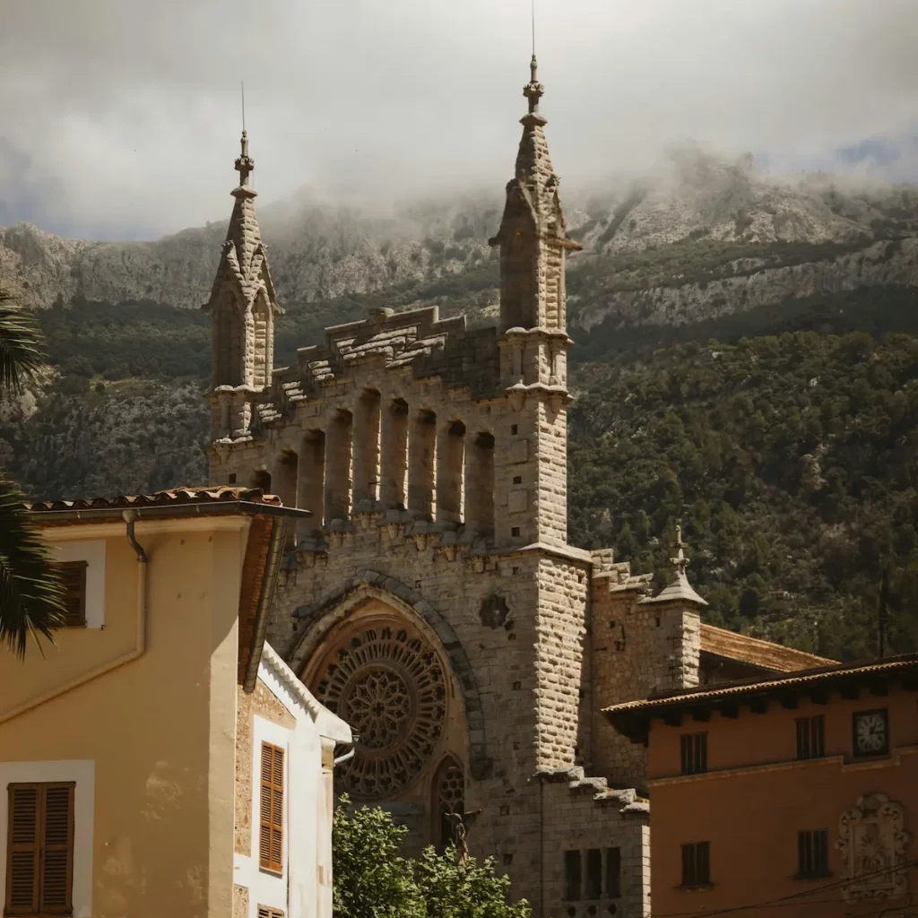 Church of Saint Bartholomew in Sóller Mallorca, a neo-Gothic landmark designed by Joan Rubió i Bellver, framed by the Tramuntana mountains