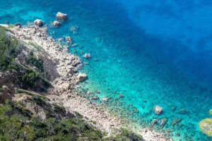 Aerial view of Sant Elm’s rocky coastline and crystal-clear turquoise water in southwest Mallorca, showcasing one of the top beaches near Port d’Andratx.